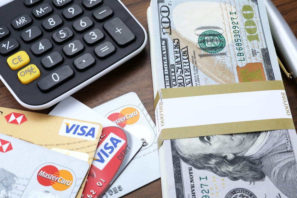 Banded stack of dollar bills with calculator and bank cards - blank template