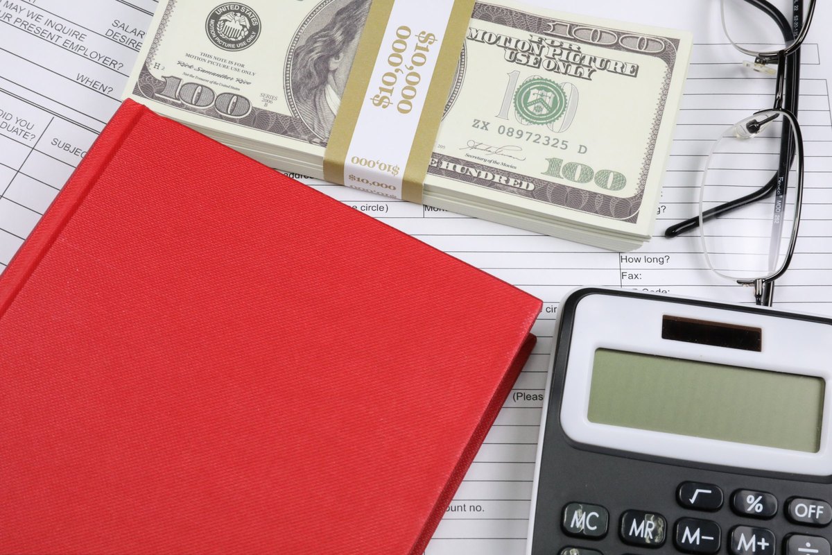 Red hardback book with dollars, glasses and calculator - blank template
