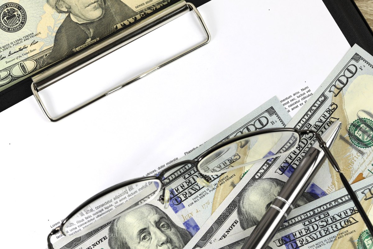 Blank paper on a clipboard with dollar bills and glasses - blank template