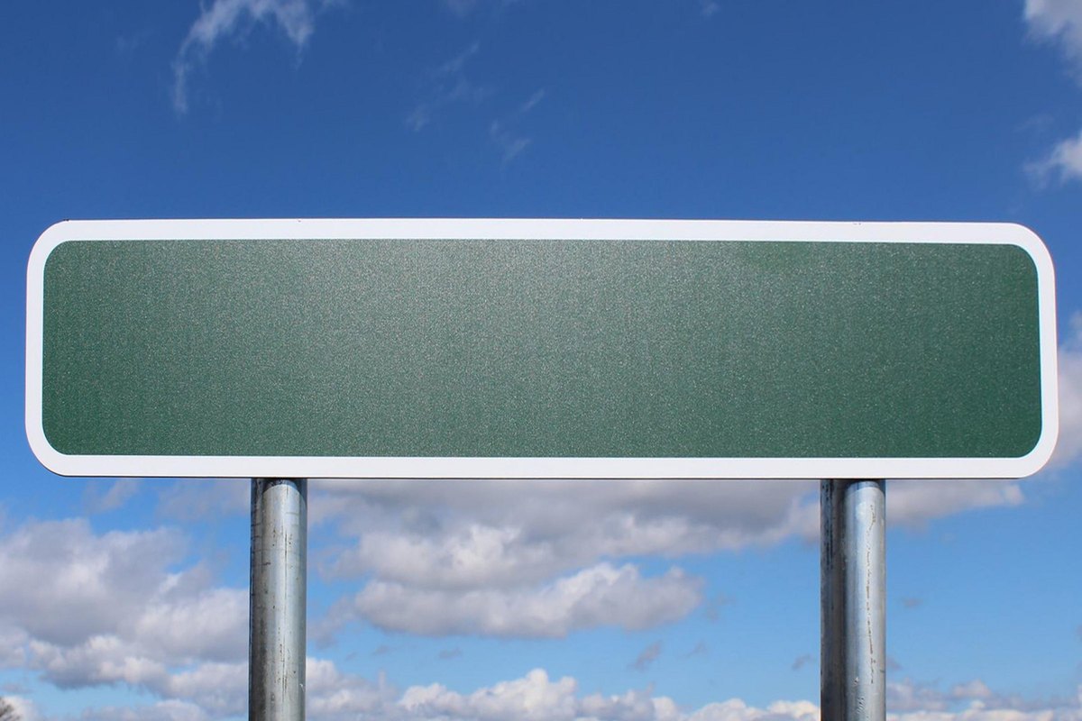 Blank green road sign against a blue sky - blank template