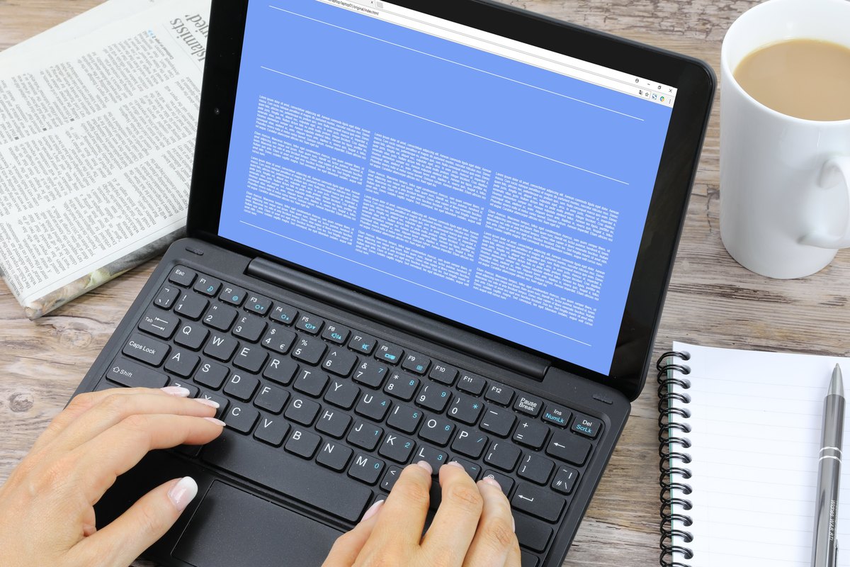 Laptop with a blank blue screen, tea and notepad - blank template