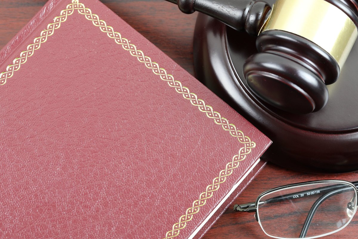 Red leather book with gold border, gavel and glasses - blank template