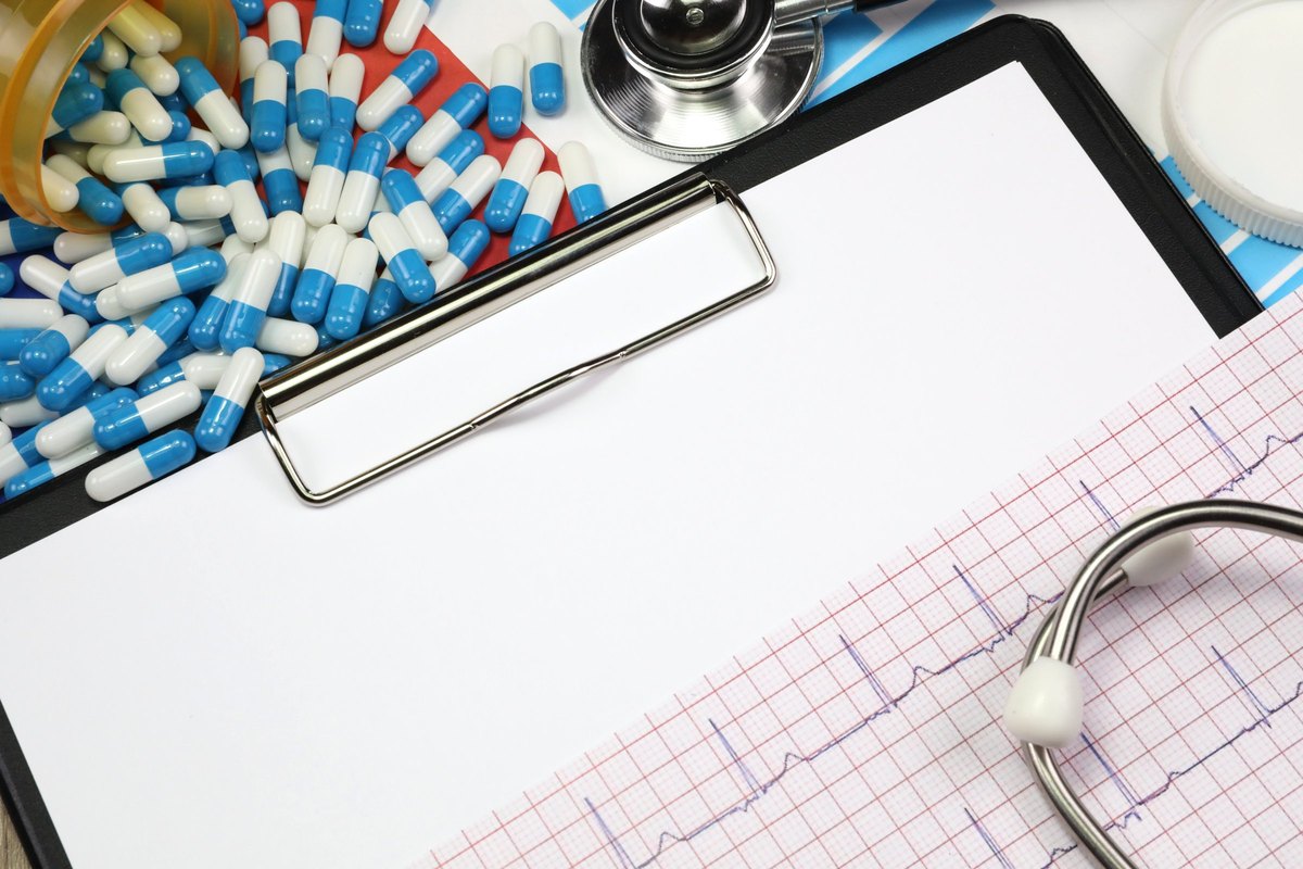Clipboard with capsules, stethoscope and heart trace - blank template