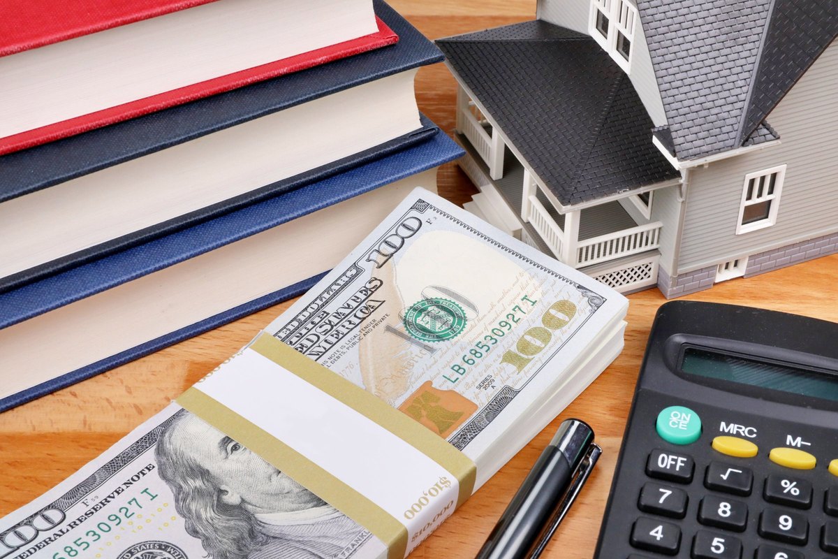 Stack of dollars with a banded label, model house and books - blank template