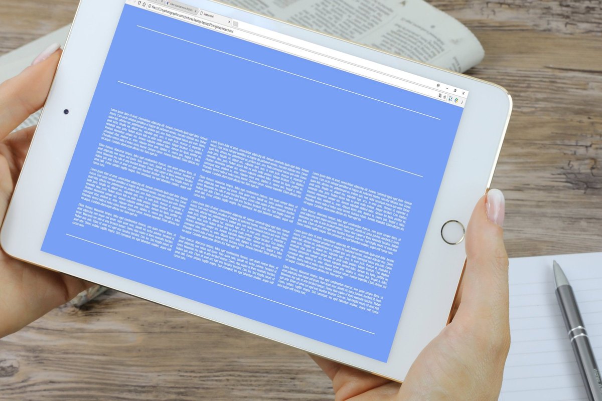 Hand holding a tablet with a blank blue screen - blank template