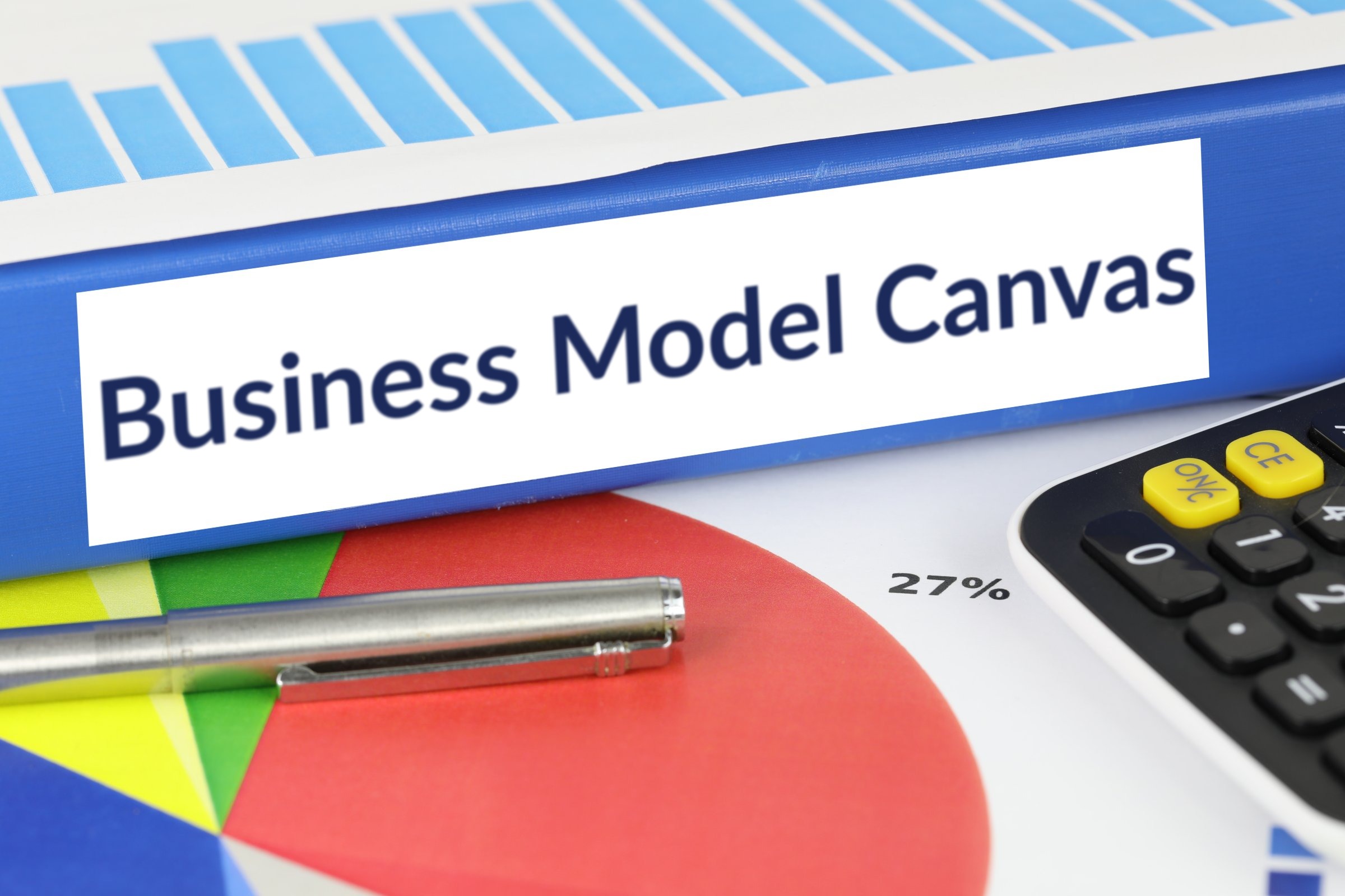 Blue ring binder with a blank label template with the words "Business Model Canvas" printed on the surface