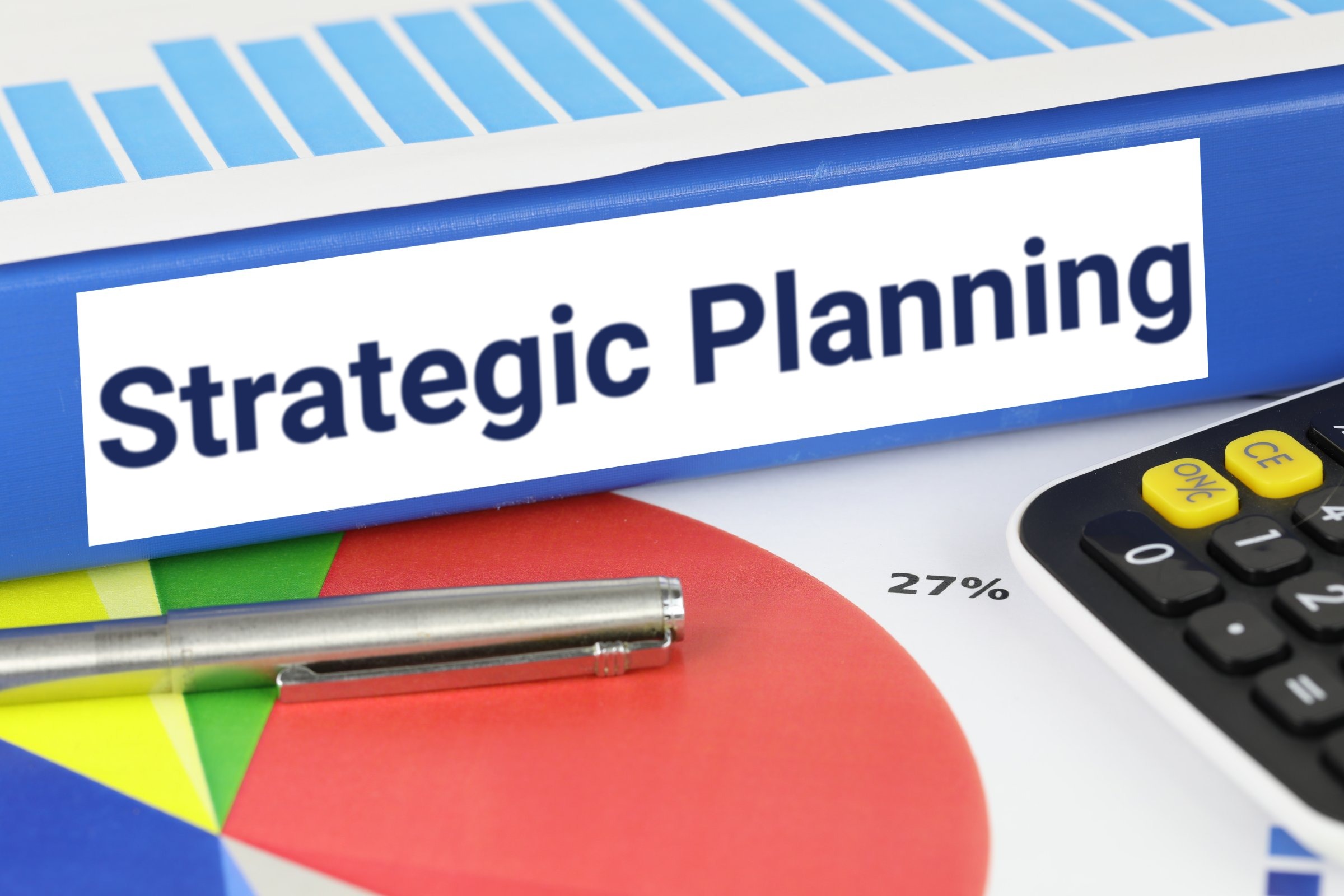 Blue ring binder with a blank label template with the words "Strategic Planning" printed on the surface