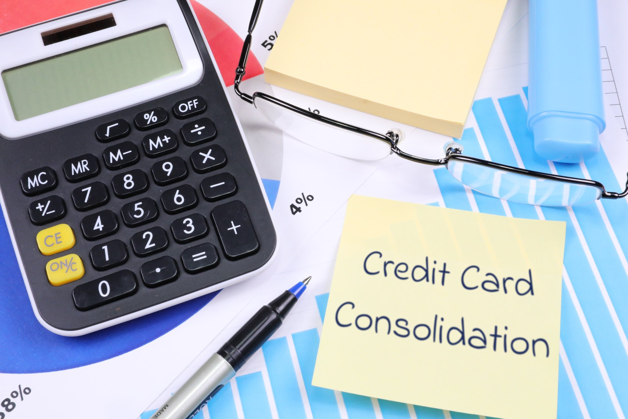 Sticky notes with calculator, glasses and pen template with the words "Credit Card Consolidation" printed on the surface