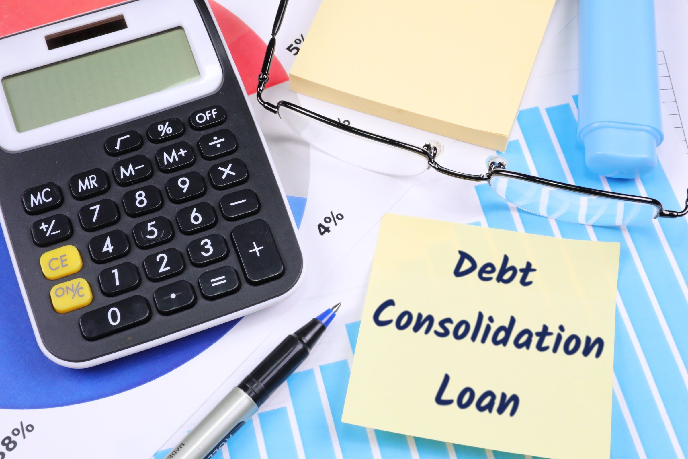 Sticky notes with calculator, glasses and pen template with the words "Debt Consolidation Loan" printed on the surface