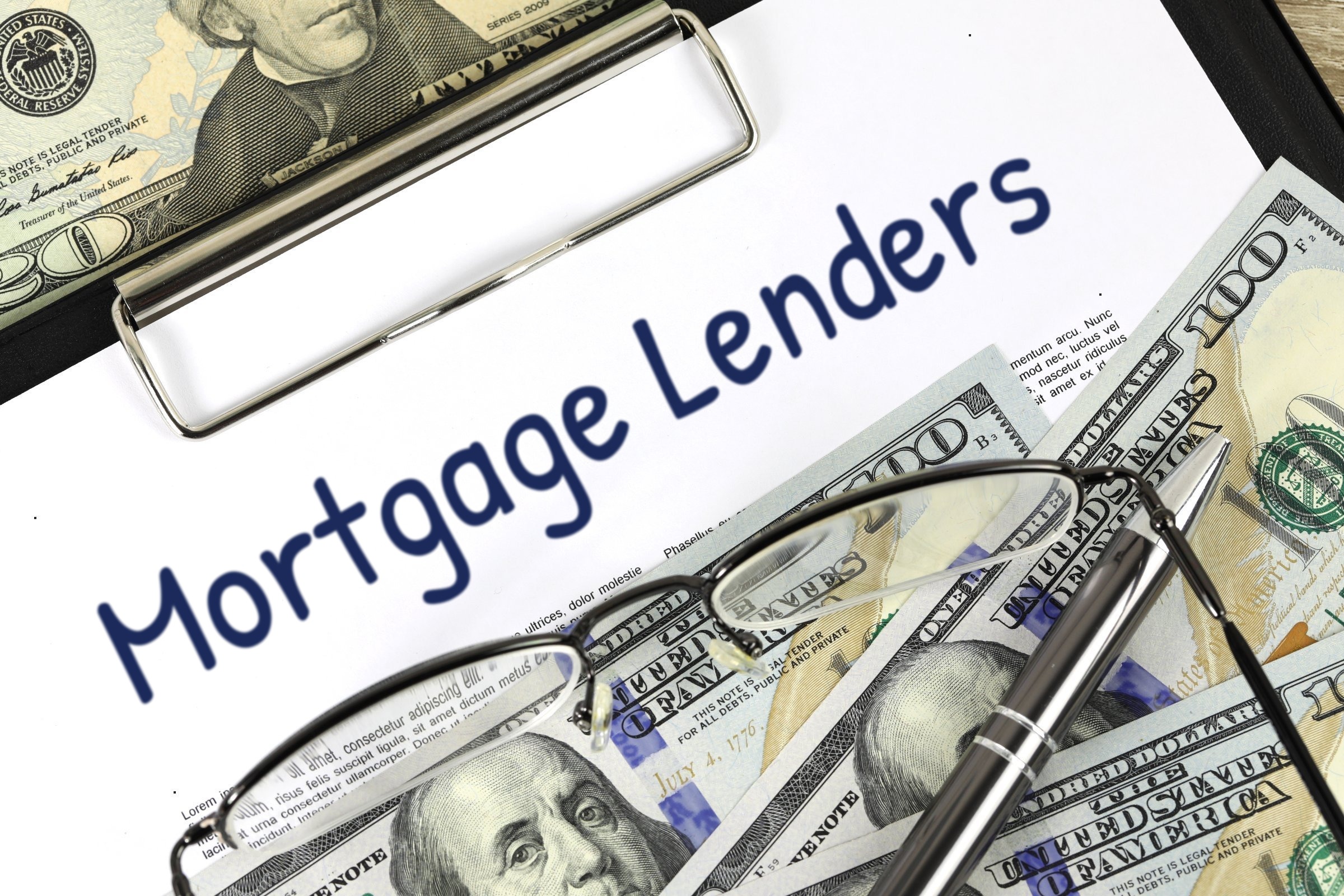 Blank paper on a clipboard with dollar bills and glasses template with the words "Mortgage Lenders" printed on the surface