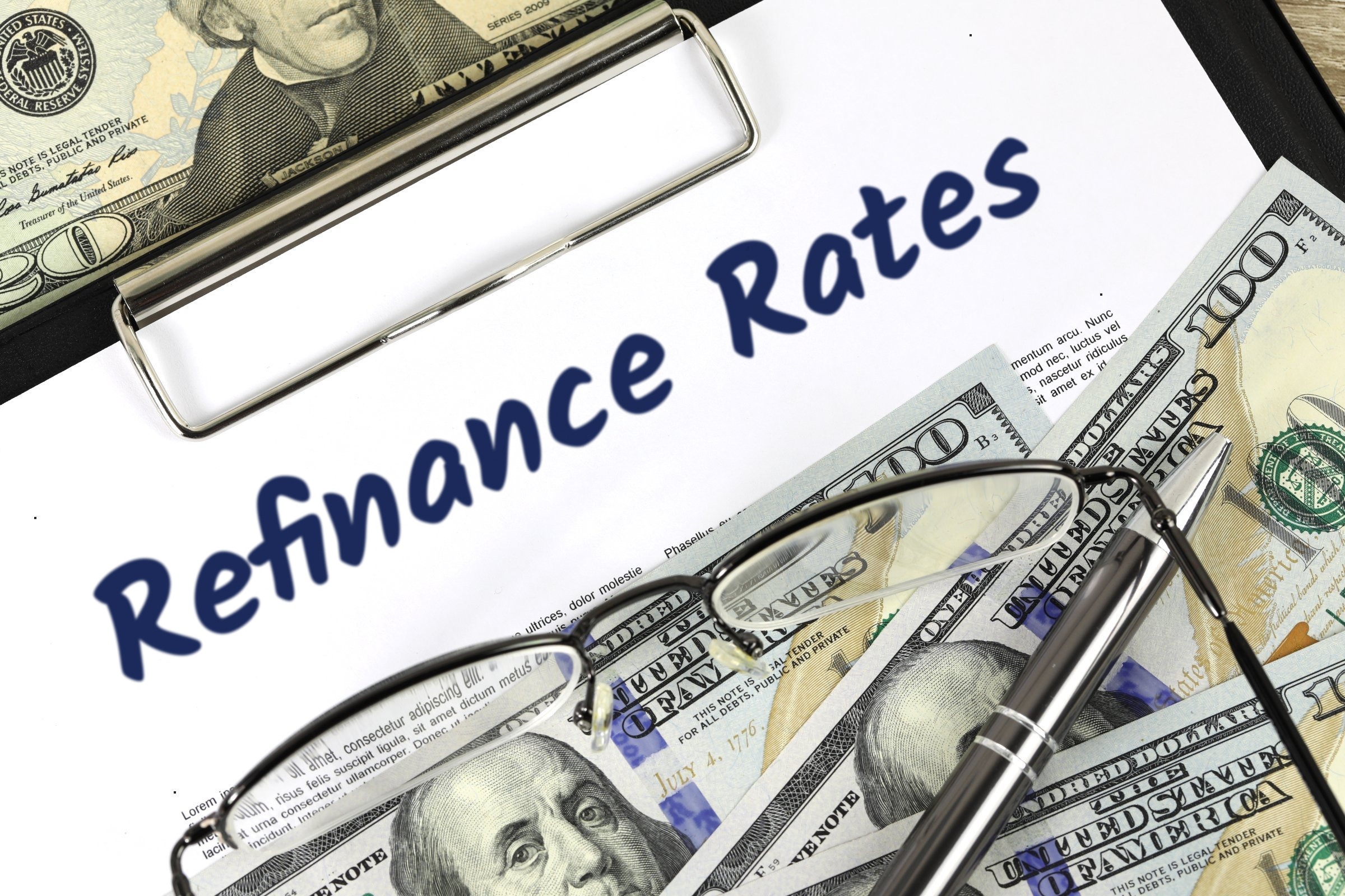 Blank paper on a clipboard with dollar bills and glasses template with the words "Refinance Rates" printed on the surface