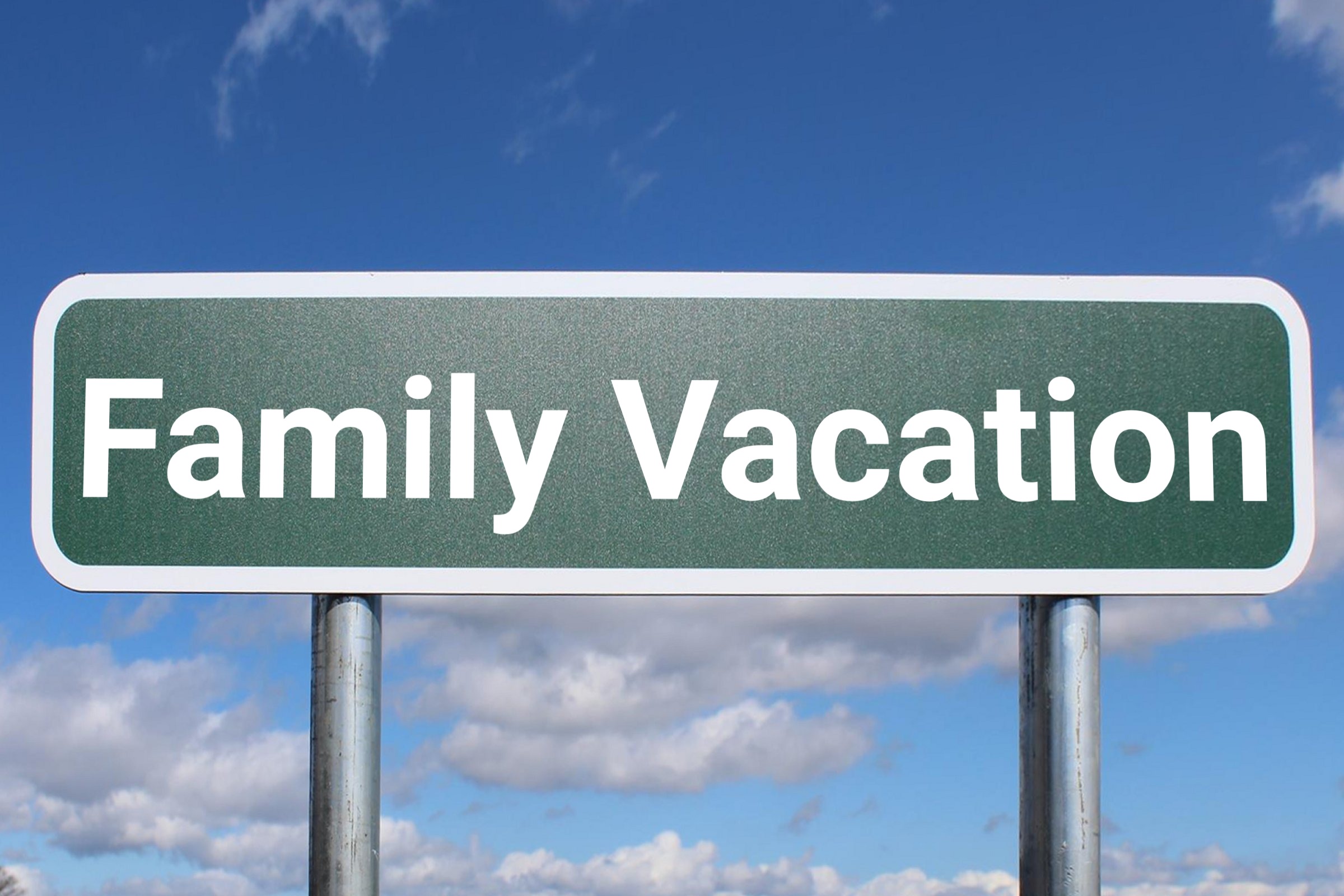 Blank green road sign against a blue sky template with the words "Family Vacation" in plain lettering