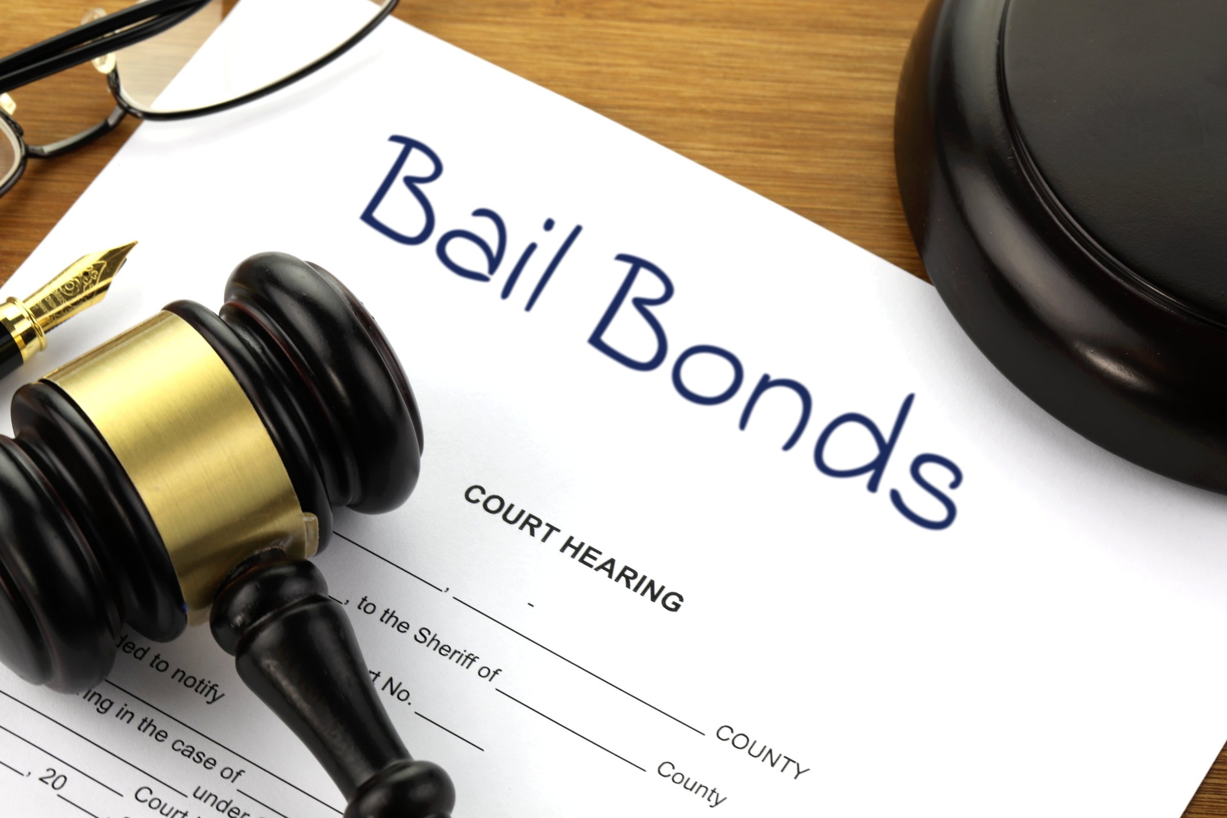 Court hearing document with gavel and fountain pen template with the words "Bail Bonds" printed on the surface