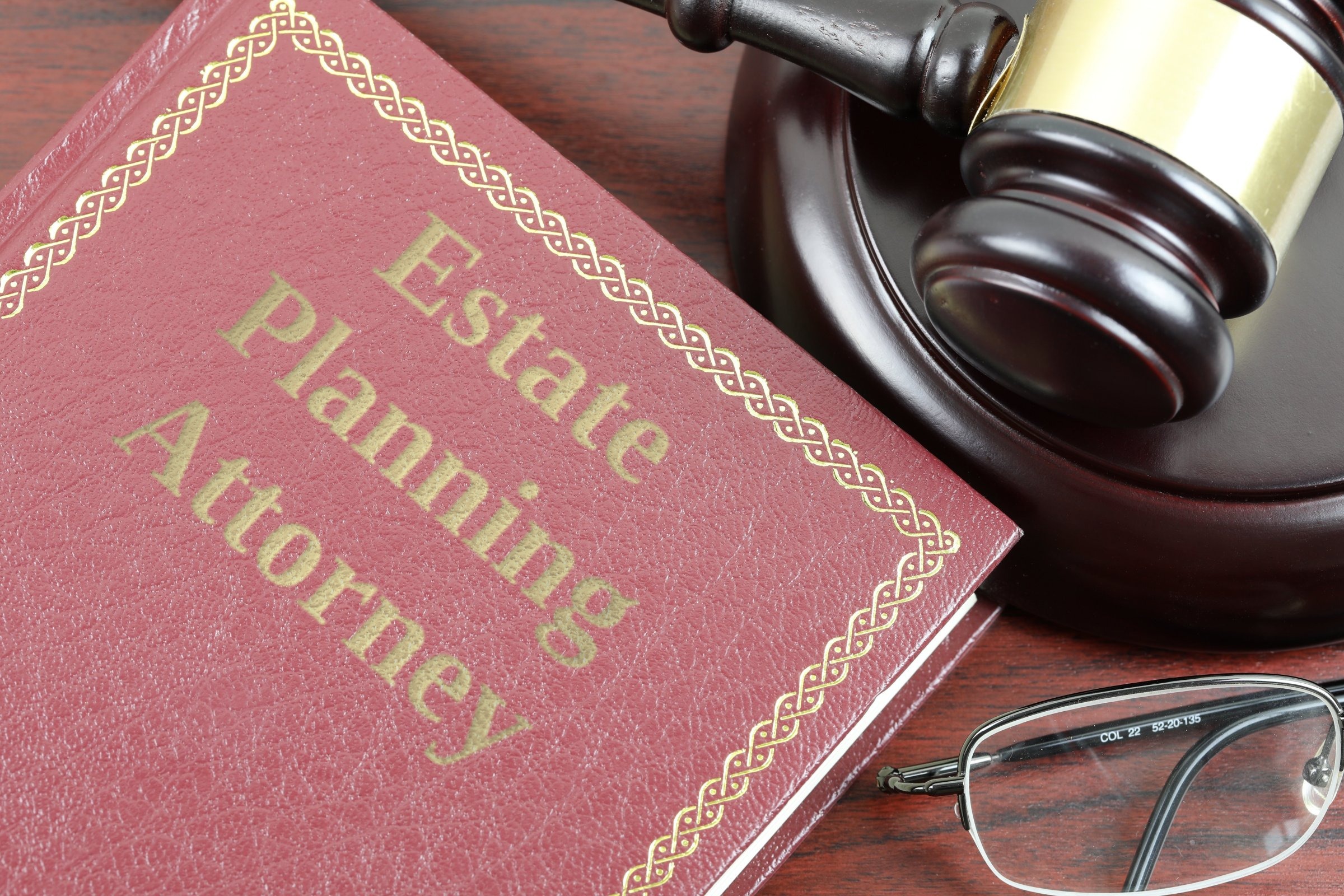Red leather book with gold border, gavel and glasses template with the words "Estate Planning Attorney" in metallic foil lettering