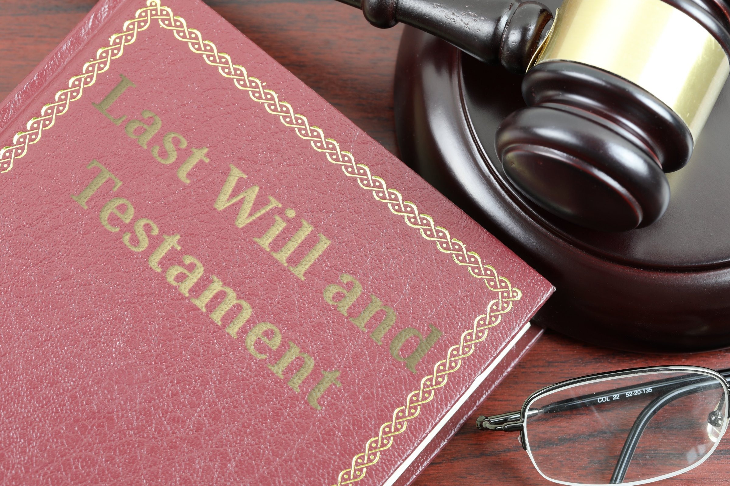 Red leather book with gold border, gavel and glasses template with the words "Last Will and Testament" in metallic foil lettering