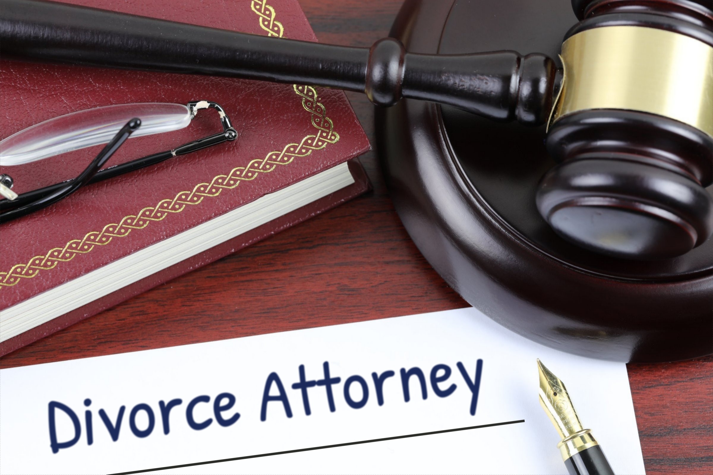 Blank paper with red book, gavel and fountain pen template with the words "Divorce Attorney" printed on the surface
