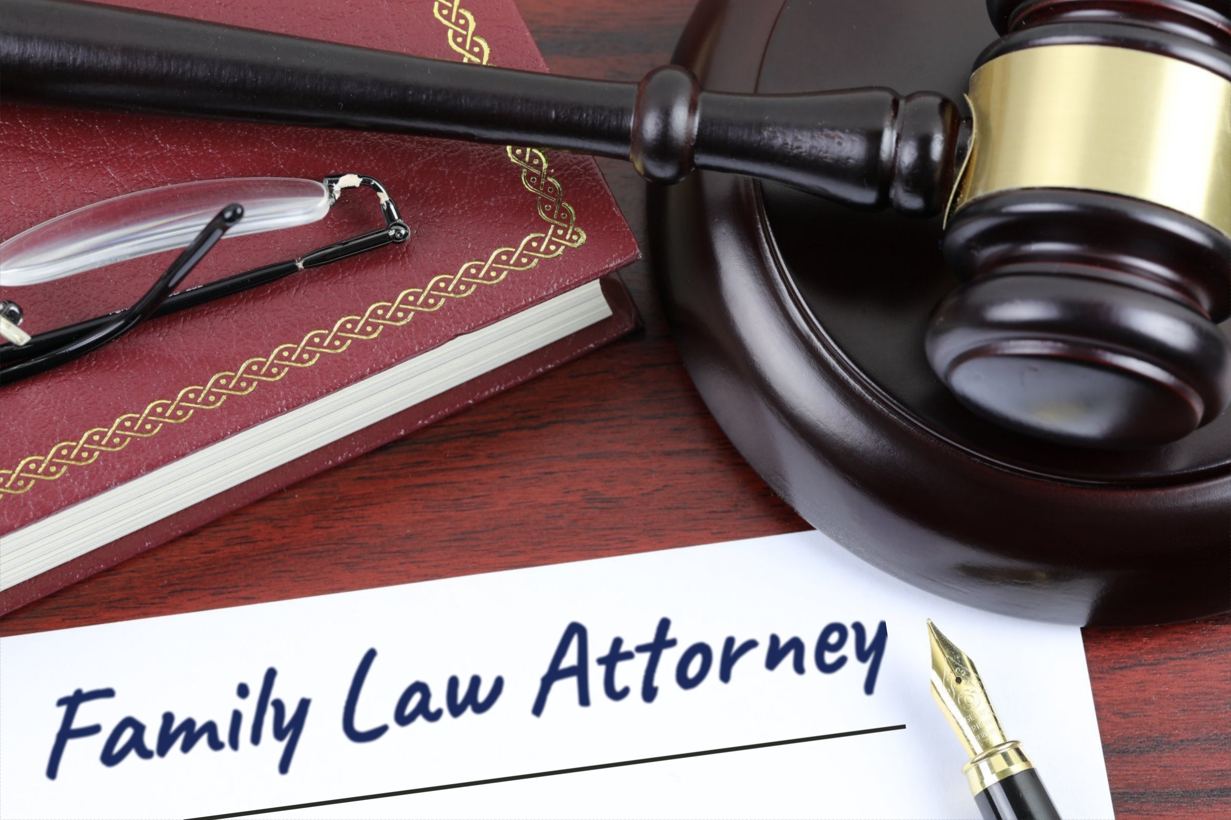 Blank paper with red book, gavel and fountain pen template with the words "Family Law Attorney" printed on the surface