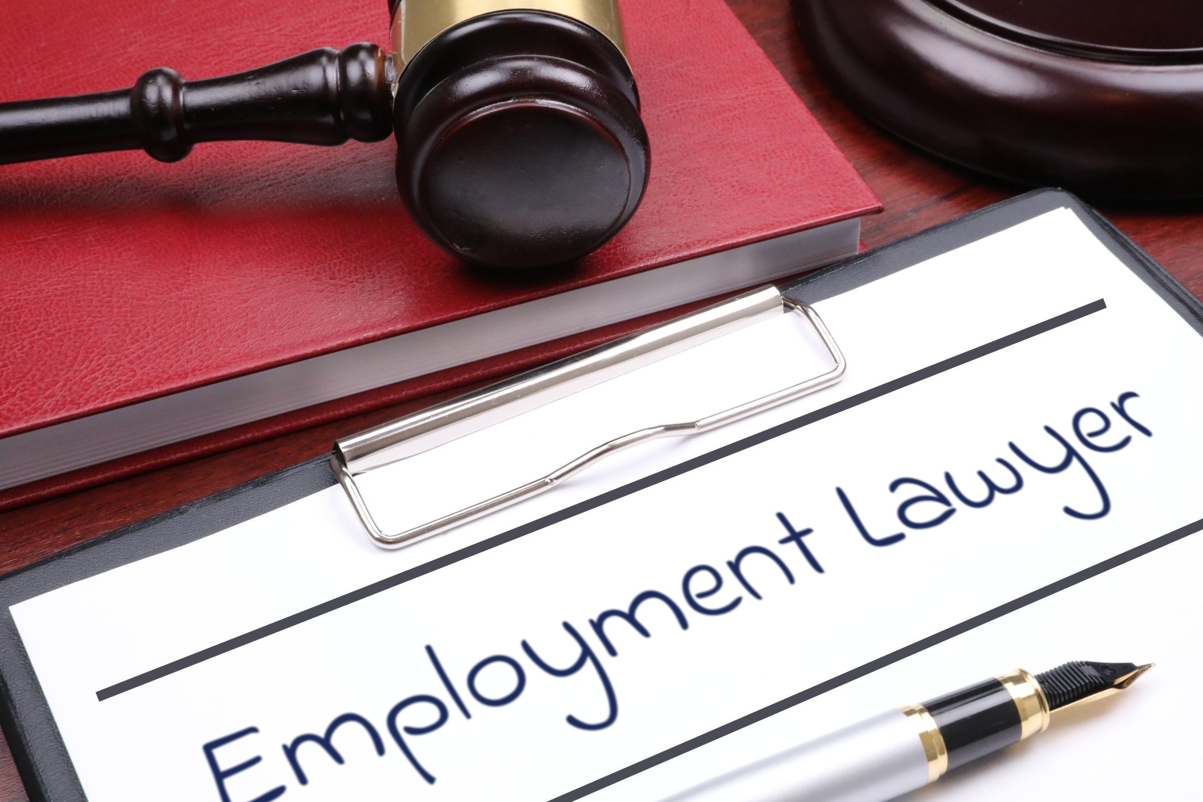 Clipboard with red book, gavel and fountain pen template with the words "Employment Lawyer" printed on the surface