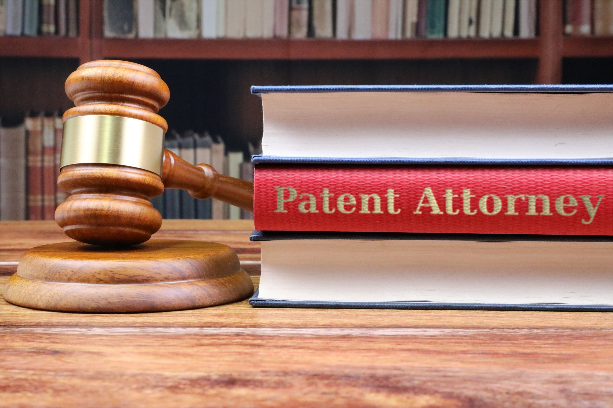 Gavel with a red book among law books template with the words "Patent Attorney" in metallic foil lettering