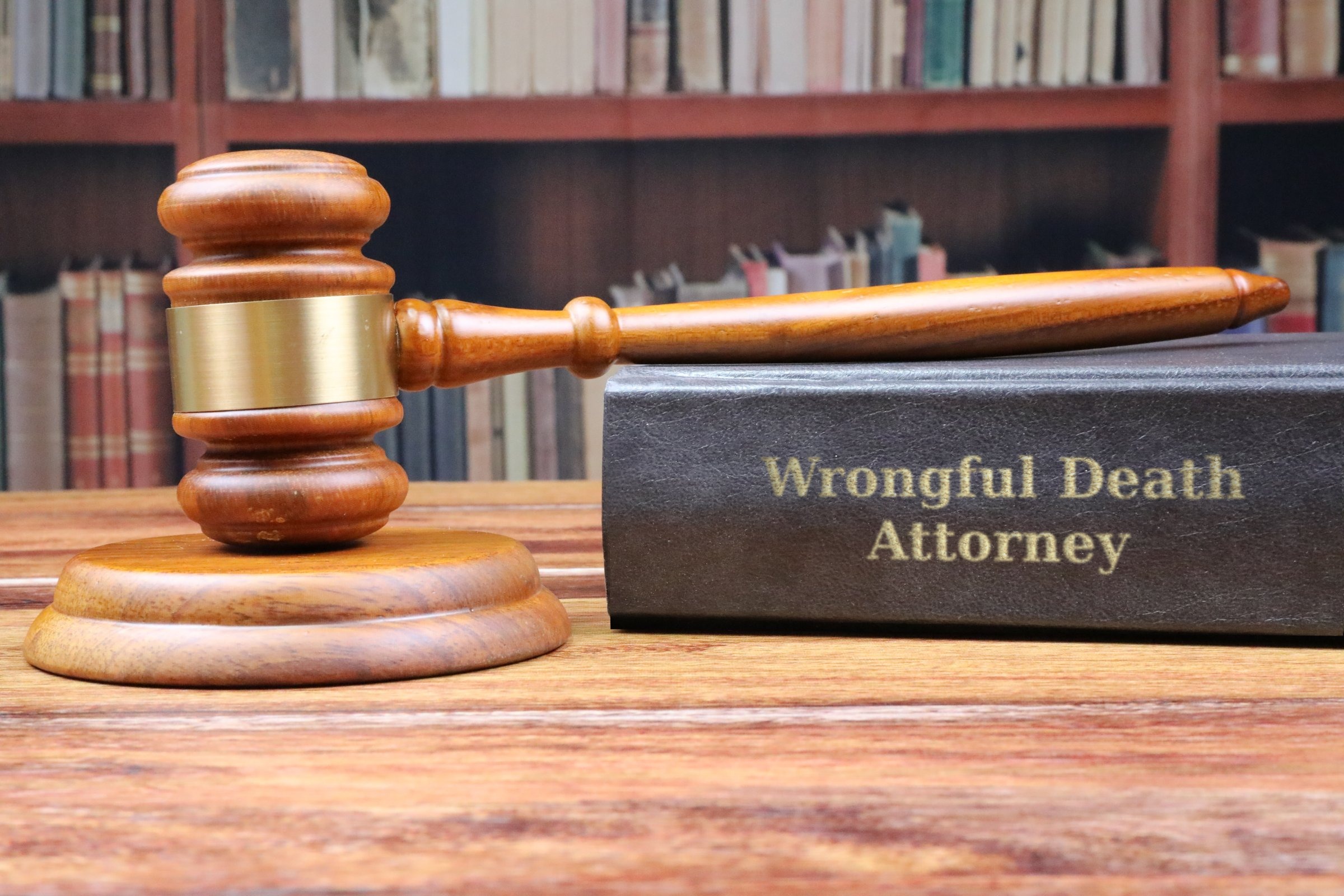Gavel and sound block with a black law book template with the words "Wrongful Death Attorney" in metallic foil lettering