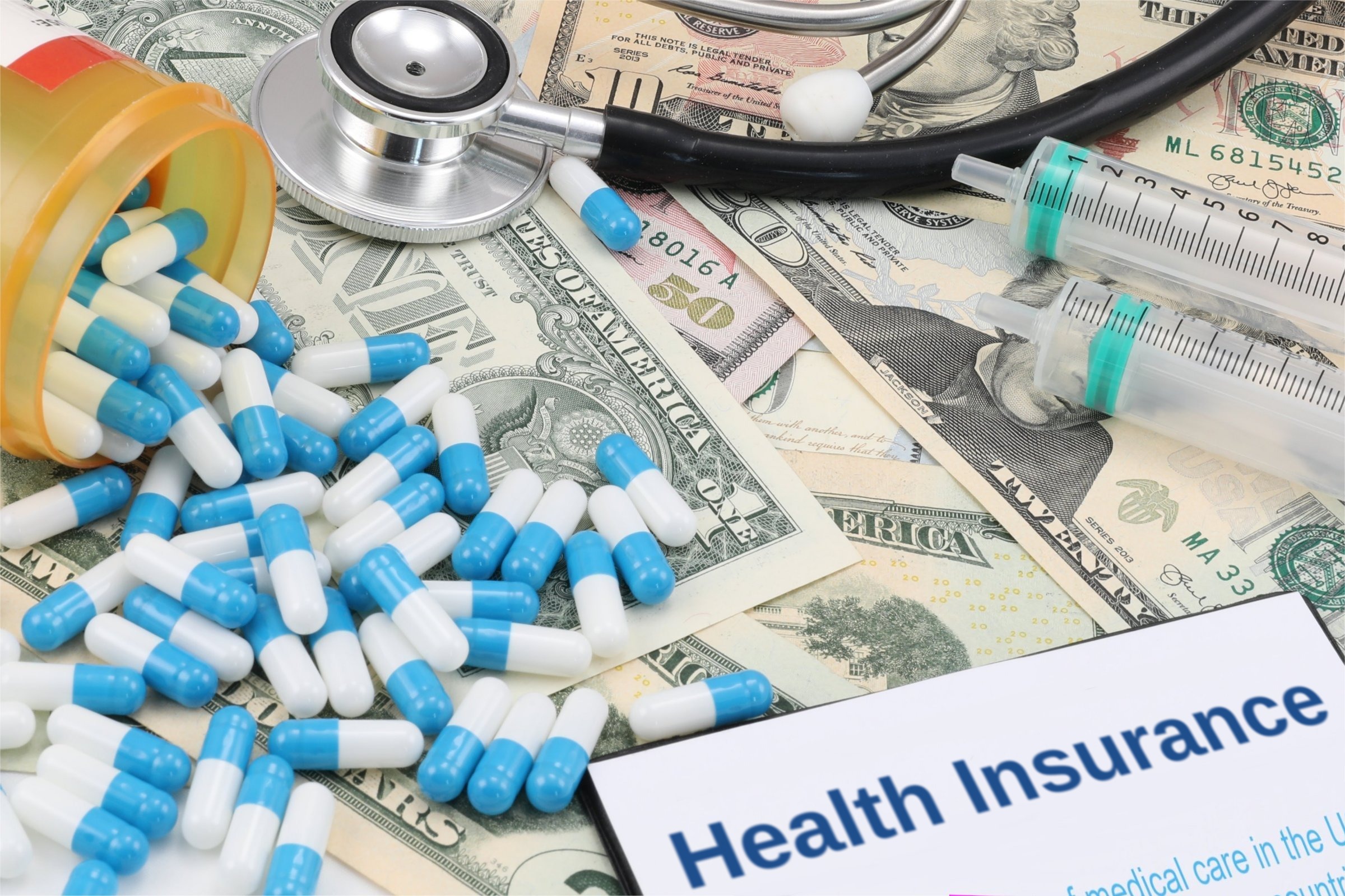Capsules, syringes and dollar bills template with the words "Health Insurance" printed on the surface