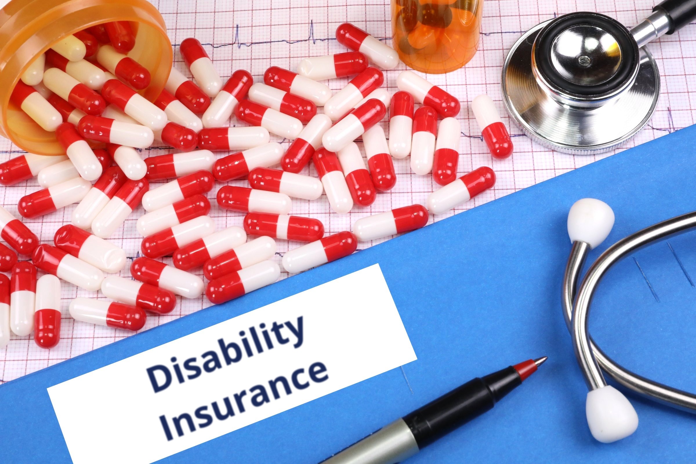 Red capsules on a blue folder with a blank label template with the words "Disability Insurance" printed on the surface