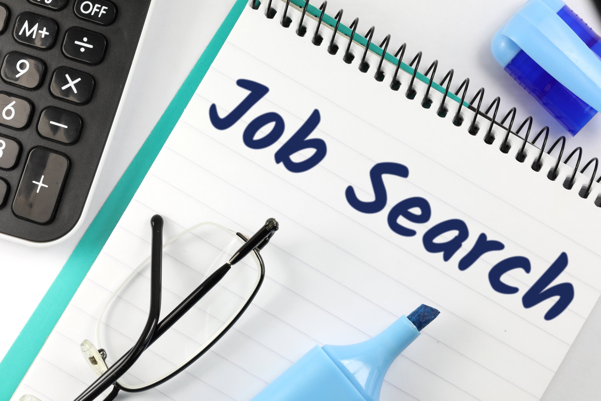 Lined spiral notepad with glasses and highlighter template with the words "Job Search" printed on the surface