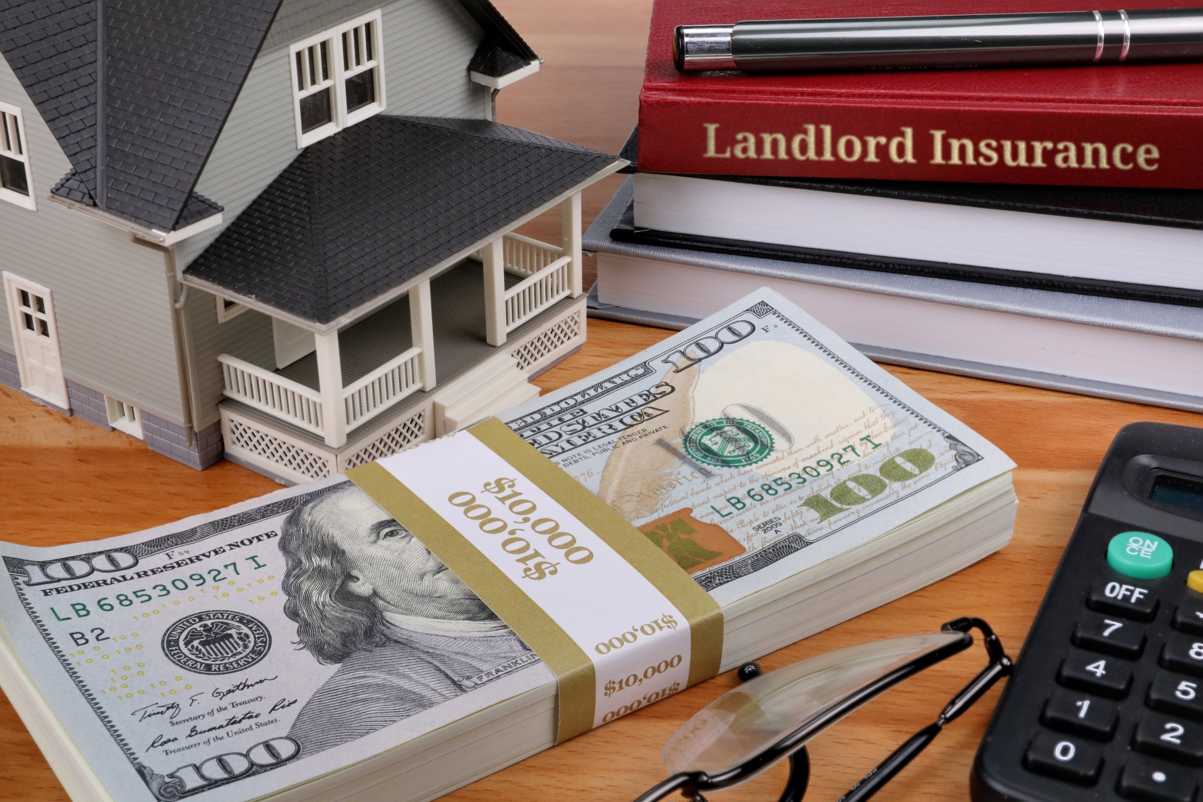 Model house with books and dollars template with the words "Landlord Insurance" in metallic foil lettering