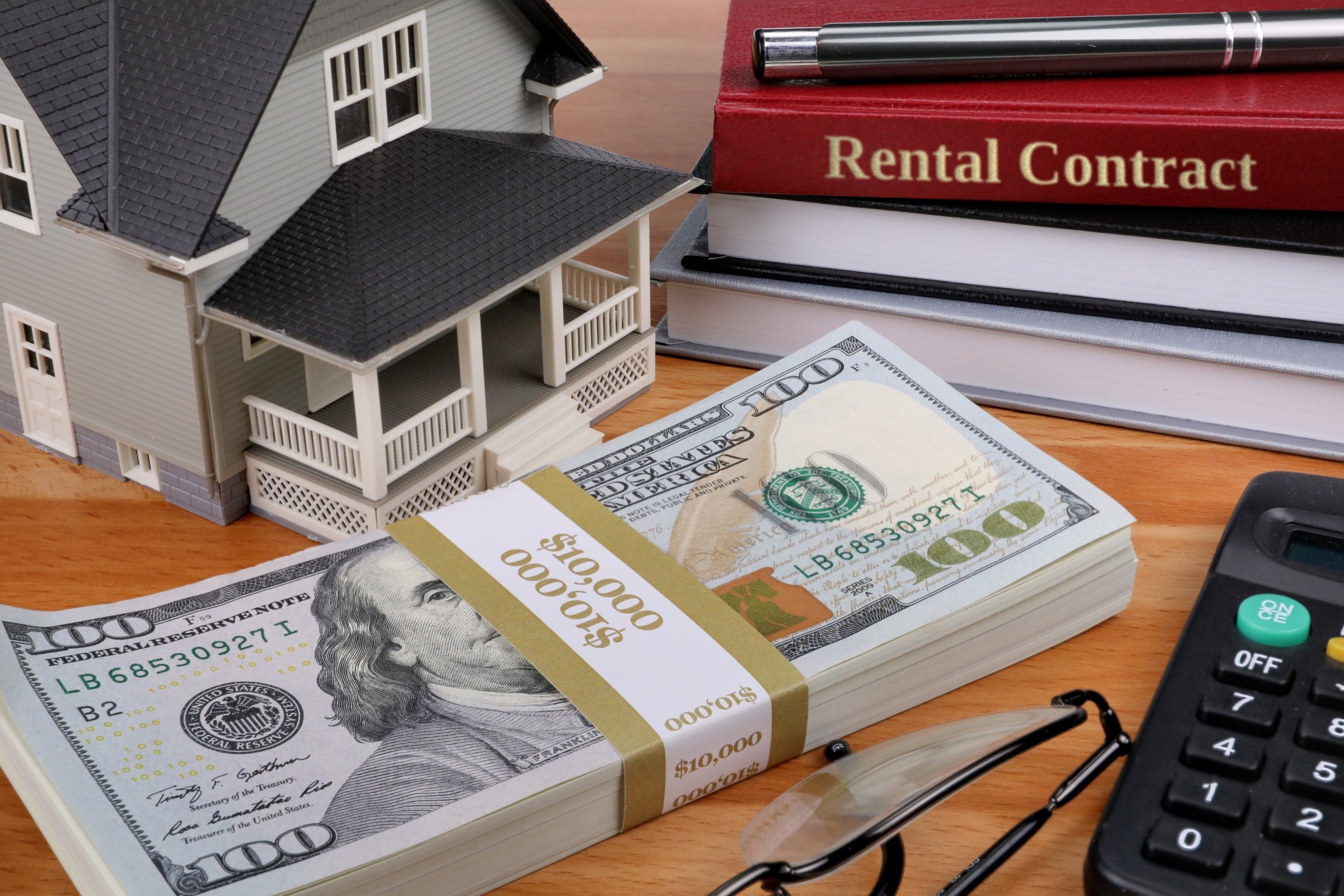 Model house with books and dollars template with the words "Rental Contract" in metallic foil lettering