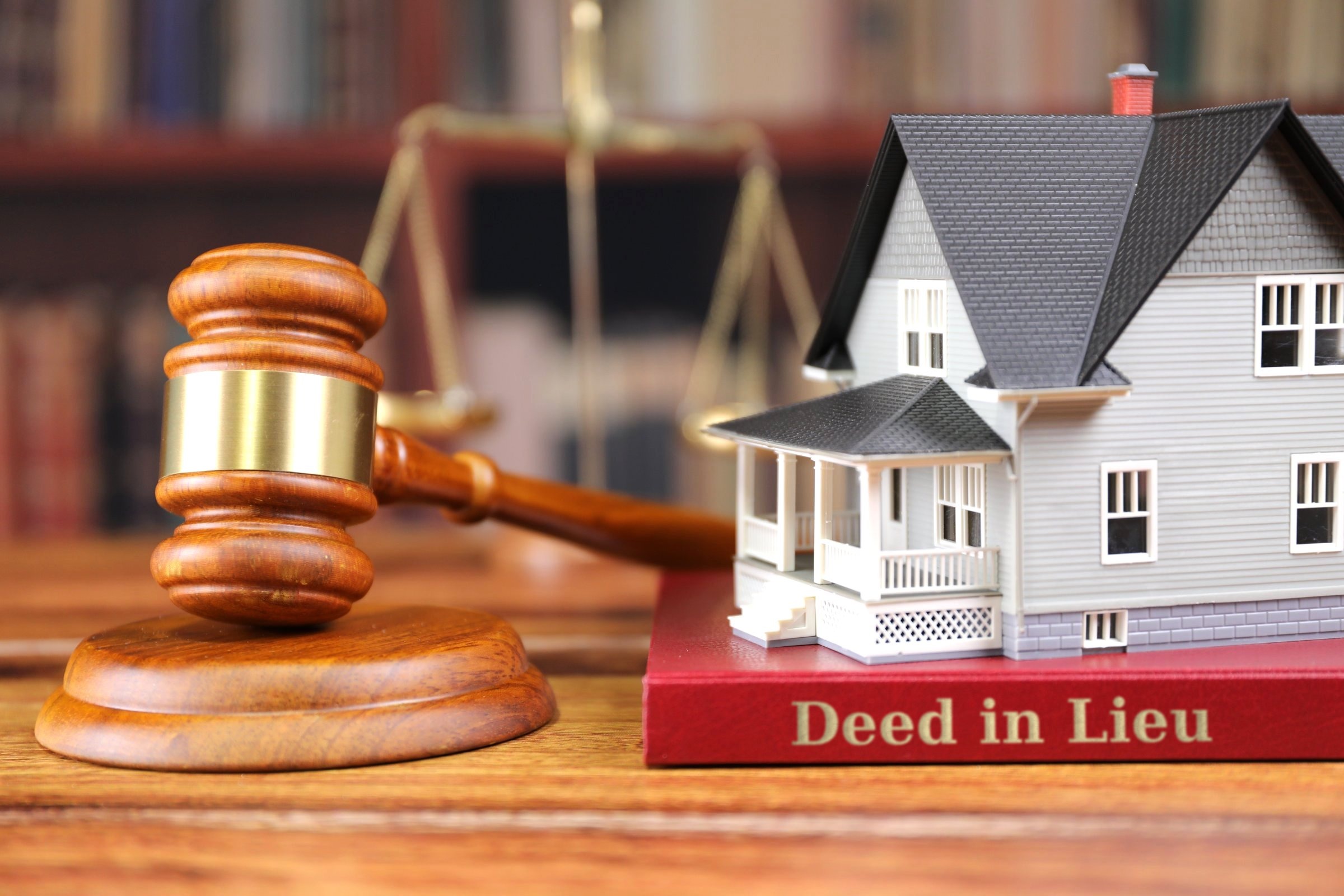 Gavel, model house and scales of justice template with the words "Deed in Lieu" in metallic foil lettering